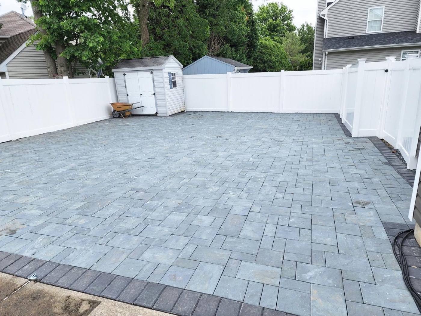 New paver patio in a fenced backyard